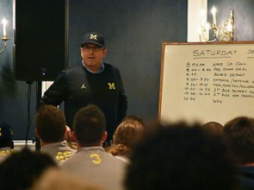 Coach Harbaugh addresses the team before the game 